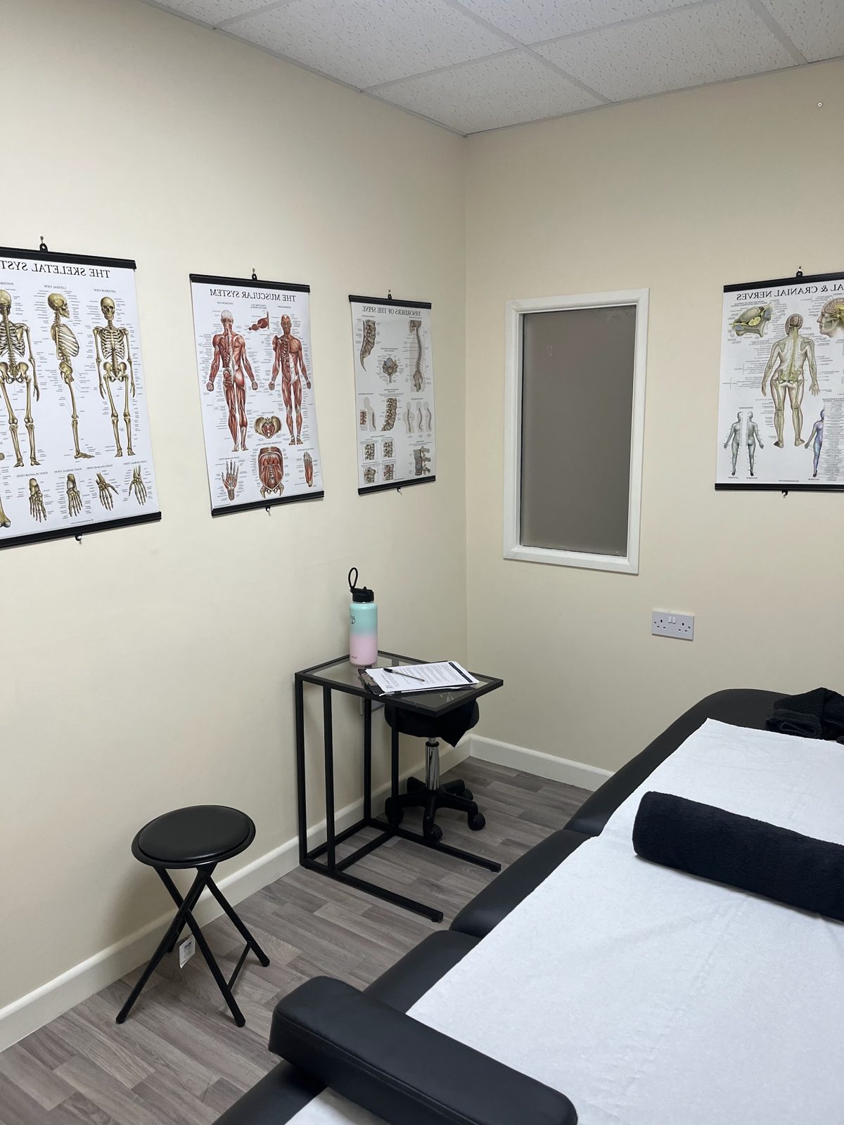 The treatment couch beneath anatomy charts